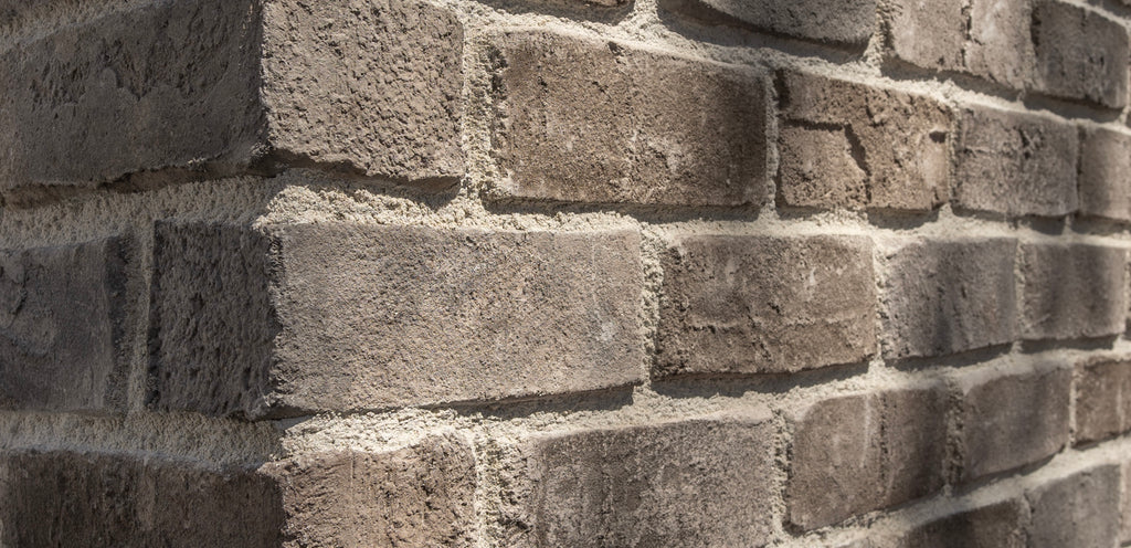 Close up detail of Creative Mines Pebblecreek Cannery Brick, including both corners and brick veneer grouted in a neutral color palette.